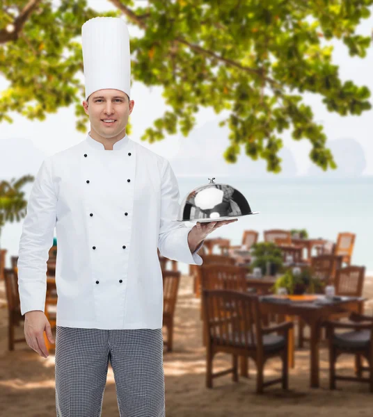 Feliz chef masculino cozinhar segurando cloche — Fotografia de Stock