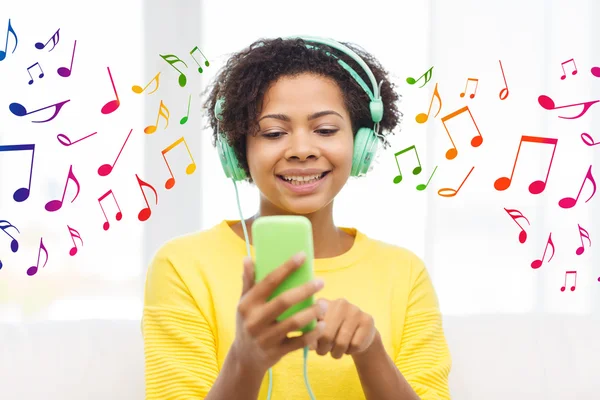 Happy african woman with smartphone and headphones — Stock Photo, Image