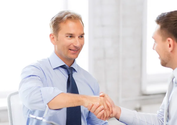 Businessmen shaking hands in office — Stock Photo, Image