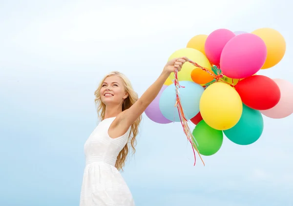 Donna sorridente con palloncini colorati all'esterno — Foto Stock