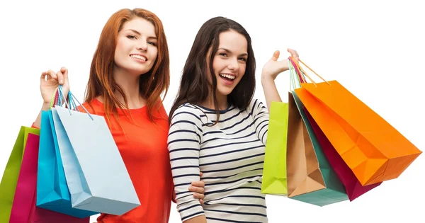 Twee glimlachend tienermeisjes met shopping tassen — Stockfoto