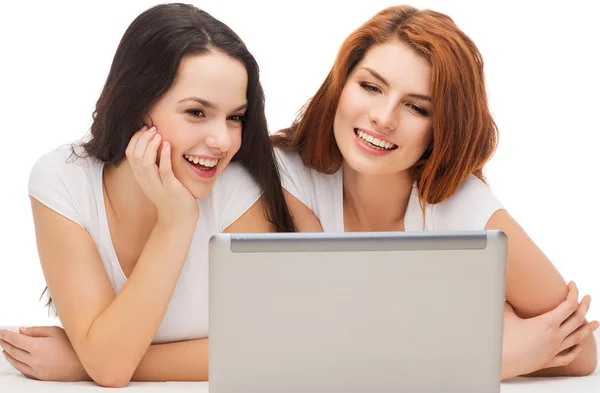 Две улыбающиеся девочки-подростки с ноутбуком — стоковое фото