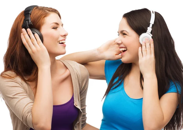 Duas garotas rindo com fones de ouvido — Fotografia de Stock