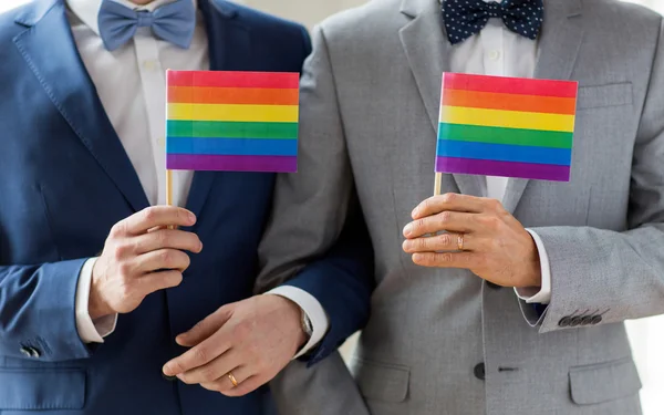 Close up de masculino gay casal segurando arco-íris bandeiras — Fotografia de Stock