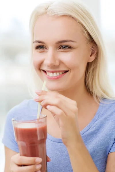 Lächelnde Frau, die zu Hause Saft trinkt oder schüttelt — Stockfoto