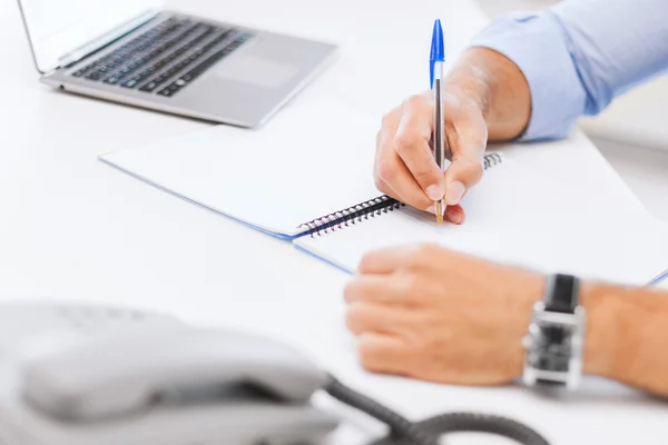 Businessman writing in notebook Stock Photo