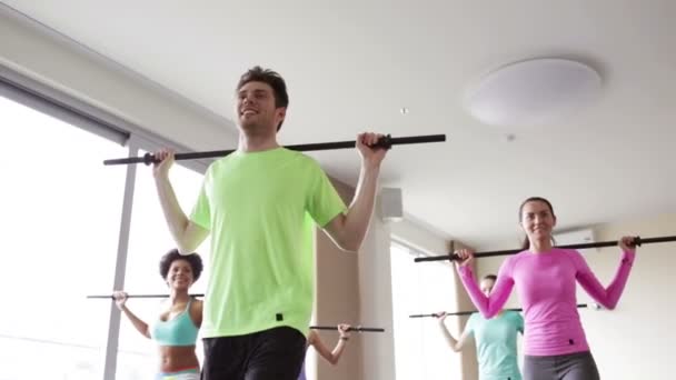 Gruppe von Menschen, die mit Bars im Fitnessstudio trainieren — Stockvideo