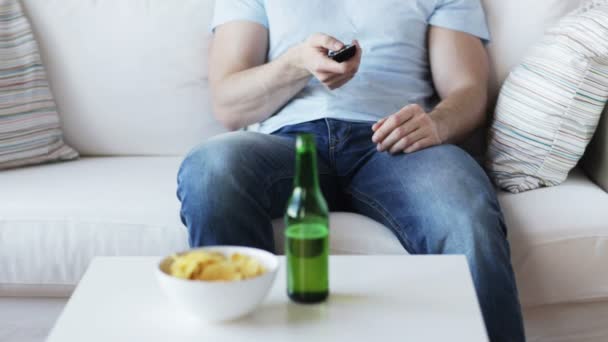 Close up of man with beer and remote at home — Stock Video