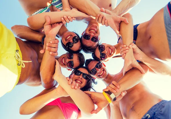 Smiling friends in circle on summer beach — Stock Photo, Image