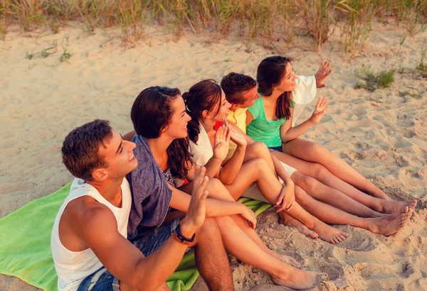 Amigos sorridentes em óculos de sol na praia de verão — Fotografia de Stock