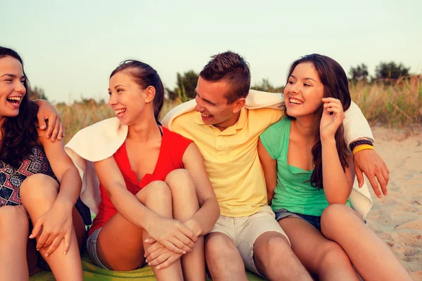 Smiling friends in sunglasses on summer beach — Stock Photo, Image