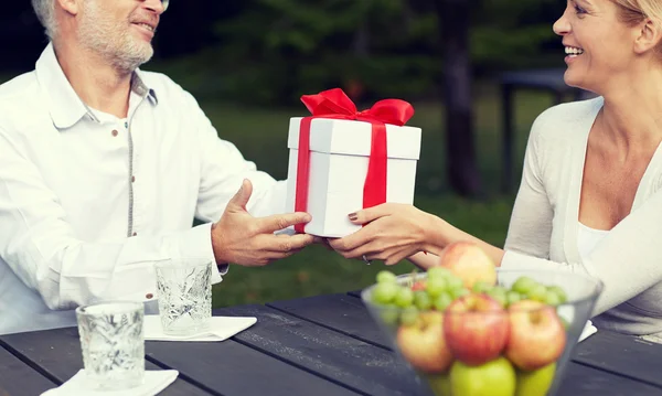 Happy family giving present in summer garden — Stock Photo, Image