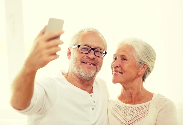 Happy senior couple with smartphone at home — Stock Photo, Image