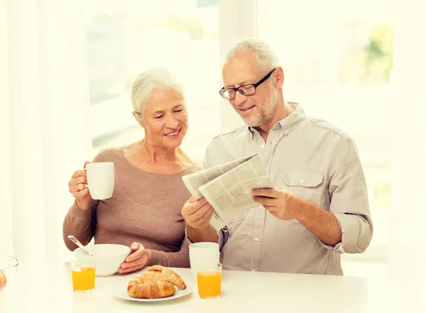 Happy senior couple having breakfast at home — Stock Photo, Image