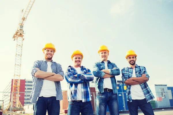 Gruppo di costruttori sorridenti in hardhats all'aperto — Foto Stock