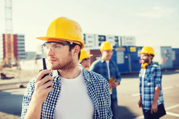 Gruppo di costruttori in hardhat con radio — Foto Stock