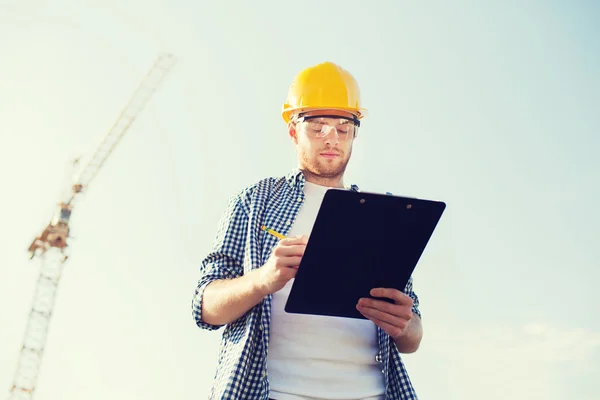 Costruttore in hardhat con clipboard all'aperto — Foto Stock