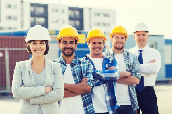 Gruppo di costruttori sorridenti in hardhats all'aperto — Foto Stock