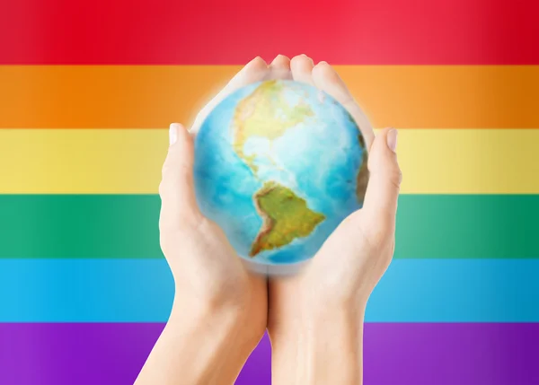Close up of hands with earth globe over rainbow — Stok fotoğraf