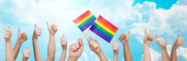 Hands showing thumbs up and holding rainbow flags — Stock Photo, Image