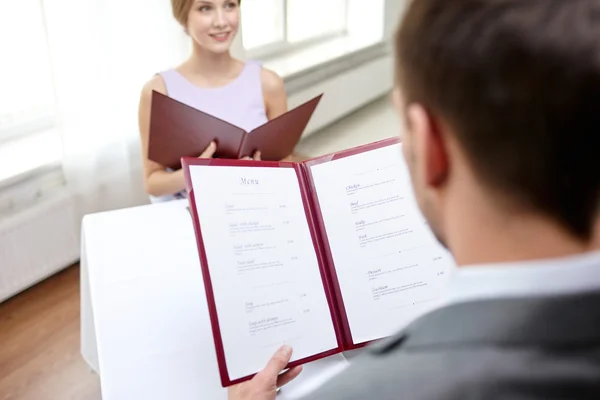 Close up of couple with menu at restaurant — Stock Photo, Image