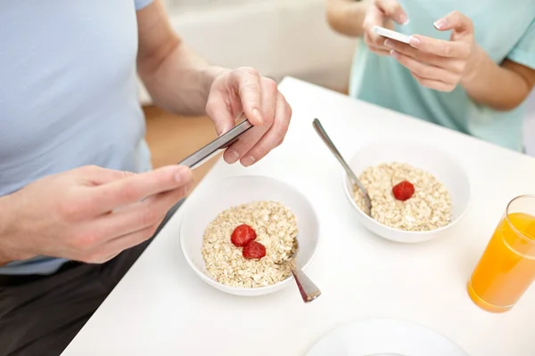 在关门的夫妇用智能手机的早餐 — 图库照片