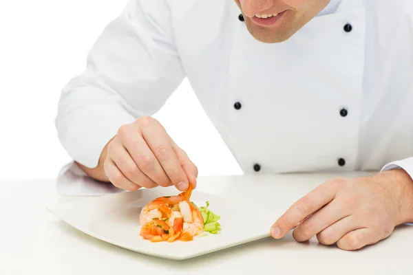 Close up of happy male chef cook decorating dish — Zdjęcie stockowe