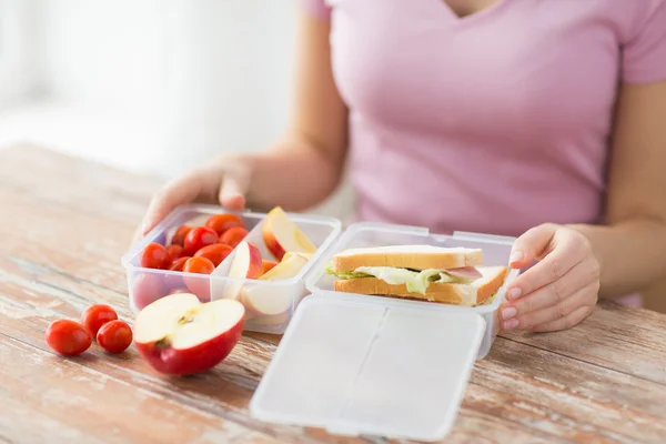 Close up of woman with food in plastic container — Stock Photo, Image