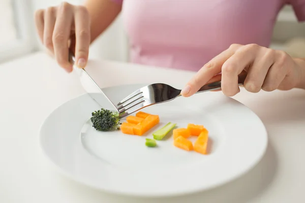 Close up van vrouw handen groenten eten — Stockfoto