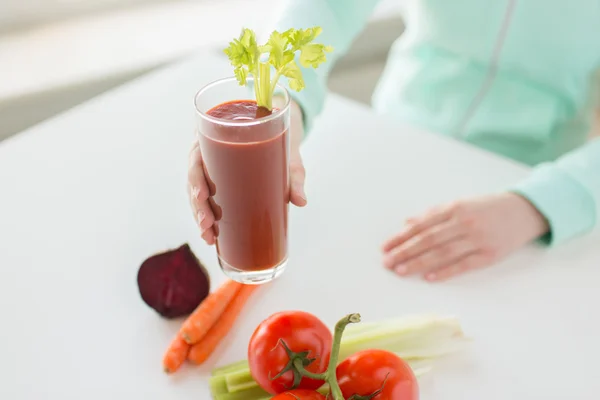 Close up of woman hands with juice and vegetables — Stock Photo, Image