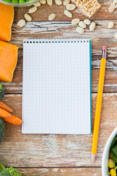 Bliska dojrzałych warzyw i notebooków na stole — Zdjęcie stockowe