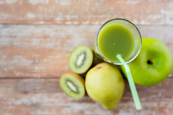 Primer plano de jugo verde fresco y frutas en la mesa —  Fotos de Stock