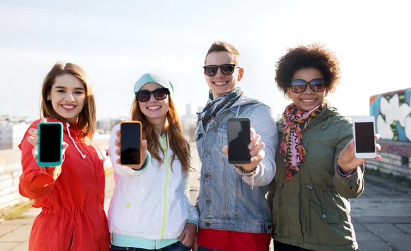 Smiling friends showing blank smartphone screens — Stock Photo, Image