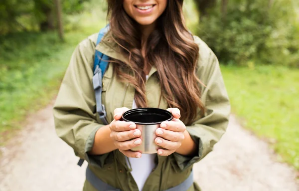 Jonge vrouw met cup en wandelen rugzak glimlachen — Stockfoto