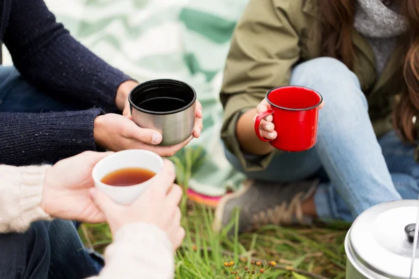 Close up of hikers drinking tea from cups at camp — Stock Photo, Image