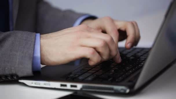 Крупним планом руки бізнесмена, що друкуються на ноутбуці — стокове відео