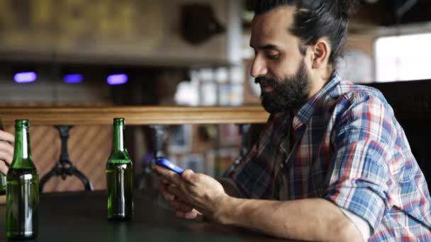 Hombre con teléfono inteligente beber cerveza en el bar o pub — Vídeo de stock