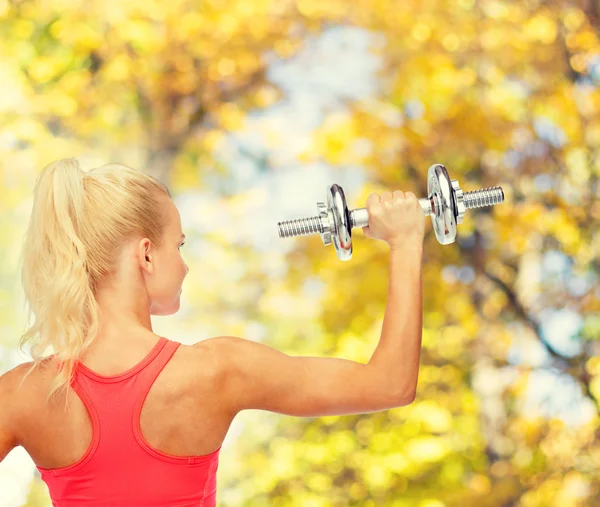 Sportiga kvinnan med tunga stål hantel från baksidan — Stockfoto