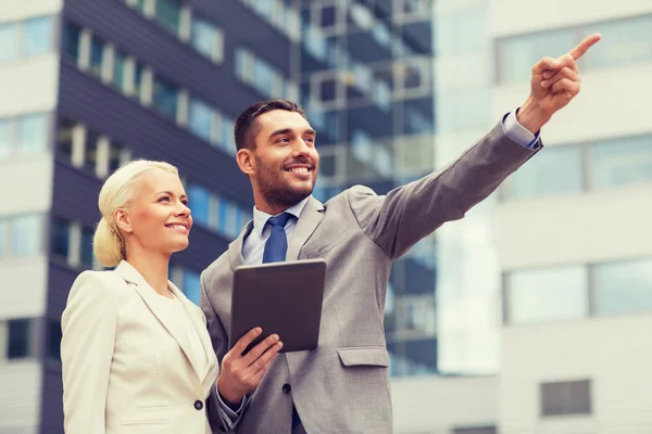 Hombres de negocios sonrientes con tableta pc al aire libre — Foto de Stock