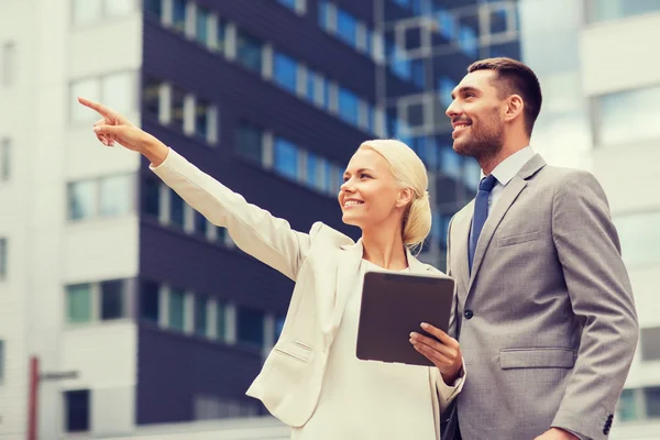 Hombres de negocios sonrientes con tableta pc al aire libre — Foto de Stock