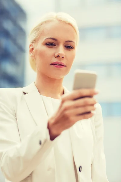 Серйозна бізнес-леді зі смартфоном на відкритому повітрі — стокове фото
