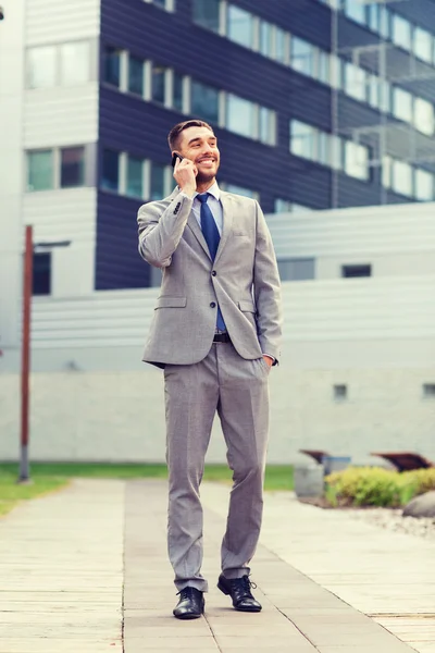 Hombre de negocios sonriente con teléfono inteligente al aire libre — Foto de Stock