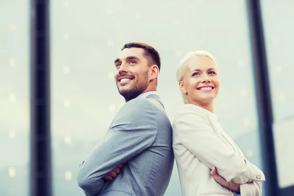 Hommes d'affaires souriants debout au-dessus de l'immeuble de bureaux — Photo