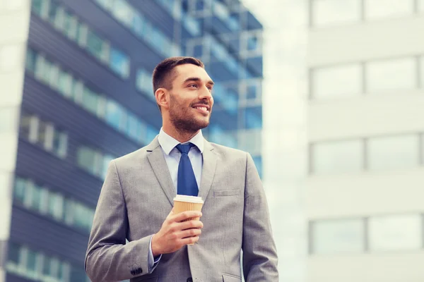 Jeune entrepreneur souriant avec extérieur de tasse de papier — Stock fotografie