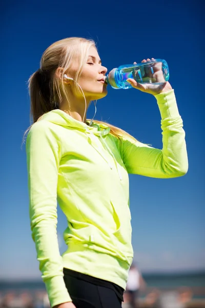 Mujer beber agua después de hacer deportes al aire libre — Foto de Stock