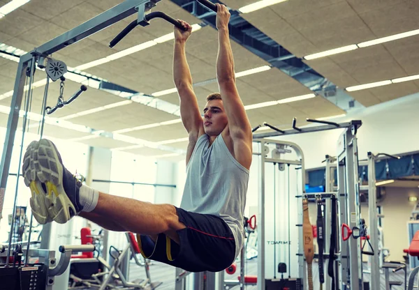 Uomo flettendo muscoli addominali sulla barra pull-up — Foto Stock