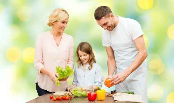 Glückliche Familie kocht Gemüsesalat zum Abendessen — Stockfoto