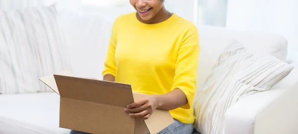 Boldog afrikai fiatal nő csomagküldő doboz otthon — Stock Fotó