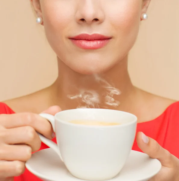 Mulher sorridente em vestido vermelho com xícara de café — Fotografia de Stock