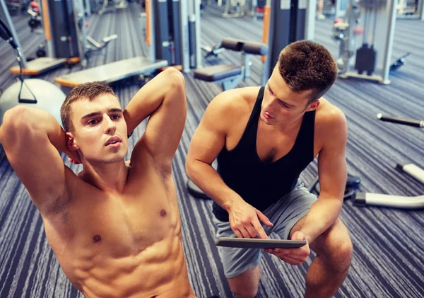 men flexing abdominal muscles in gym